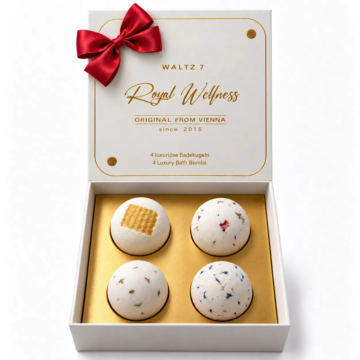 WALTZ 7 Royal Wellness Badekugeln Geschenkset: geöffnete weiße Geschenkbox mit roter Schleife und vier Badekugeln auf goldenem Einleger